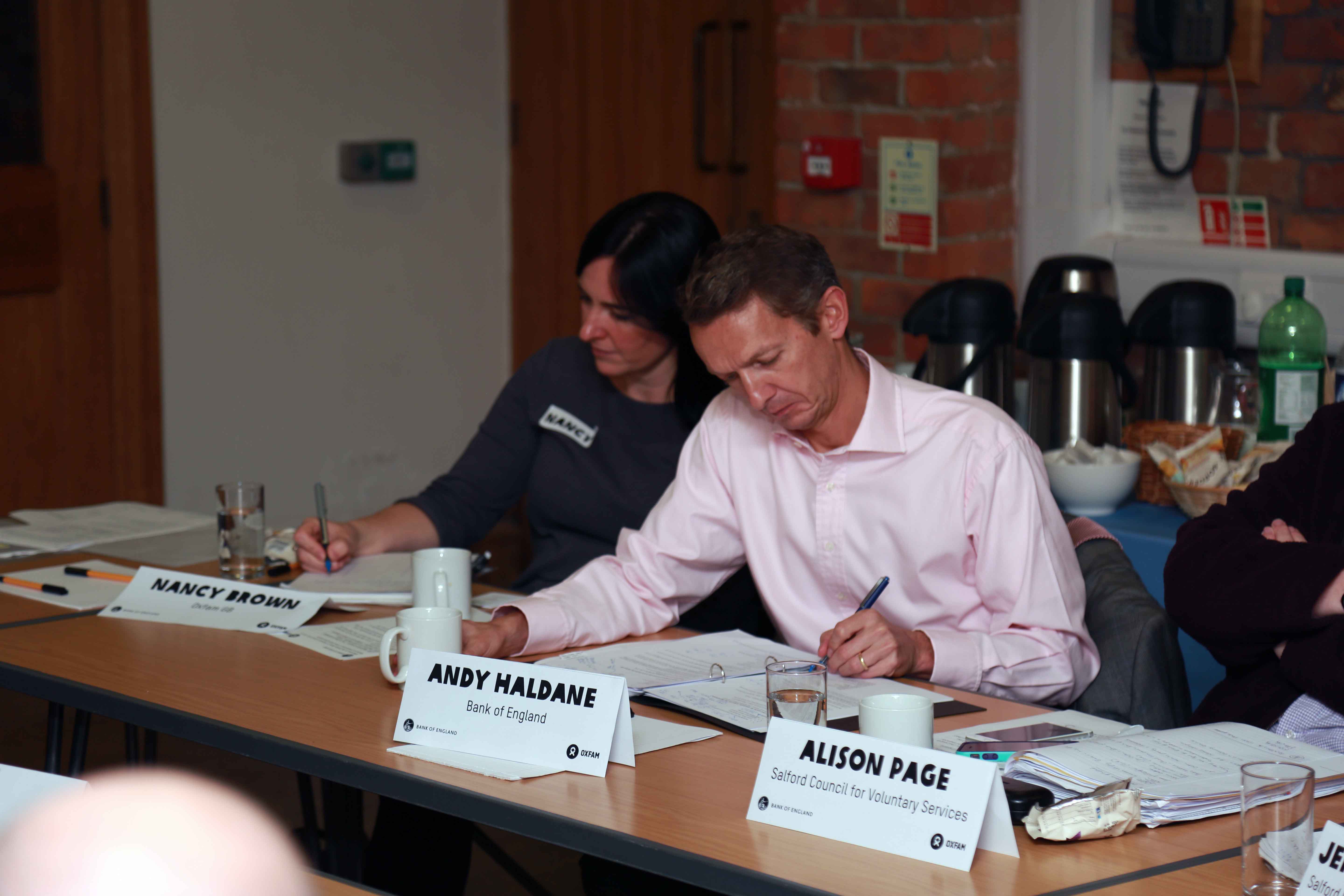A group of people around a table writing notes